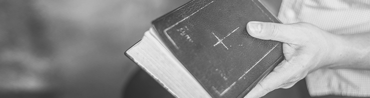 Hand resting on an well-worn family bible.