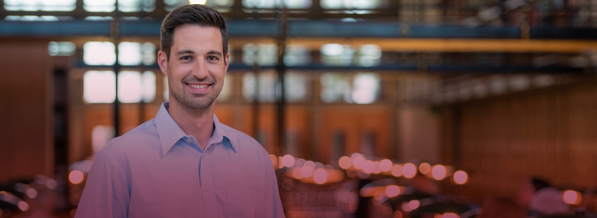 man smiling at camera inside warehouse